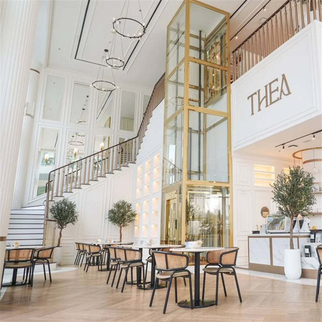 Thea interior with brass and white architectural details